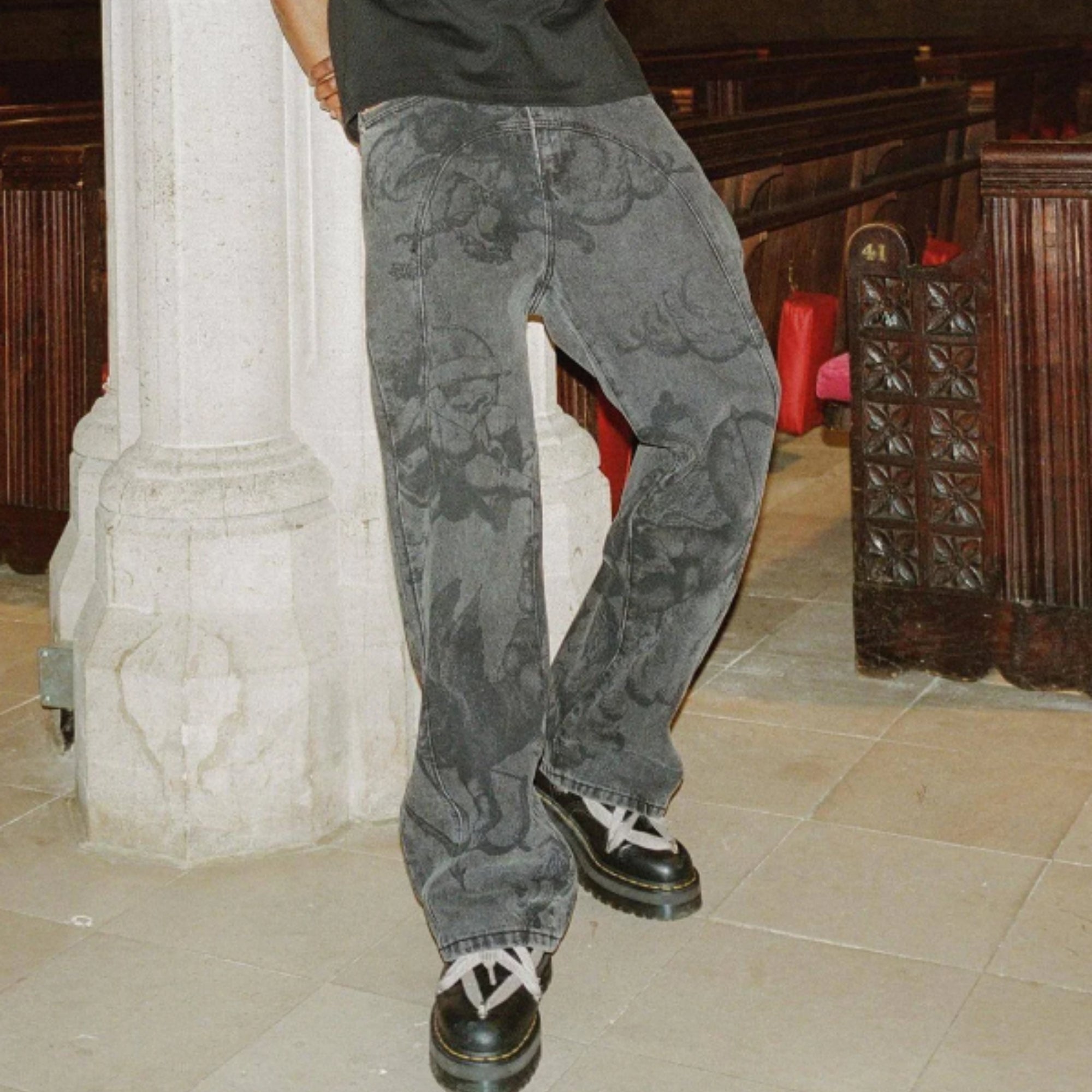 Person wearing gray floral-patterned jeans in an indoor setting