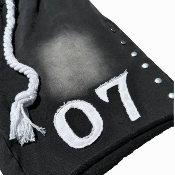 Black graduation cap with white tassel and '07' embroidery on a white background