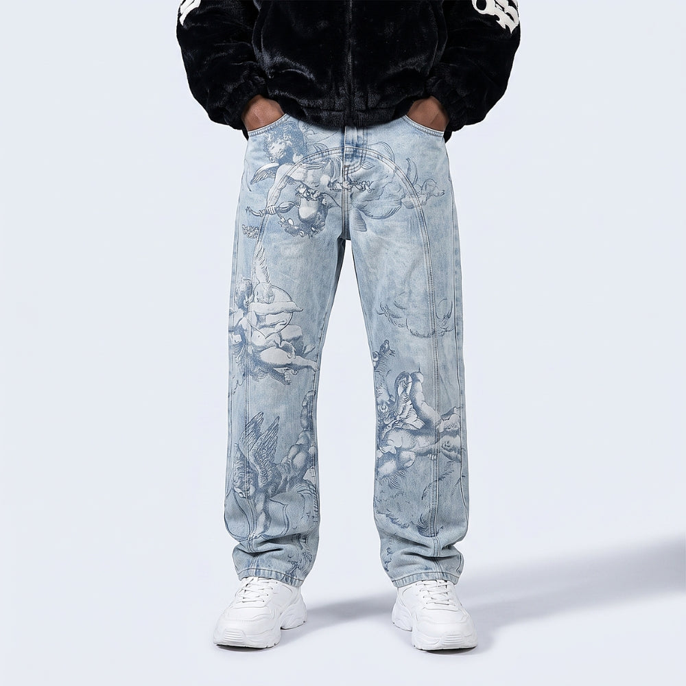 Off-White. A person wearing light-wash denim jeans with a faded classical toile-style print, paired with white sneakers and a black jacket, shown from the chest down.
