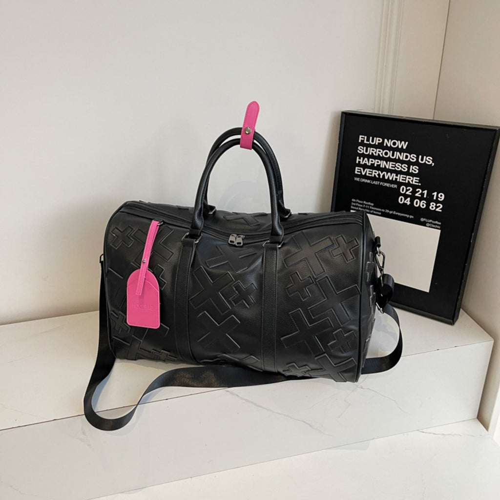 Black textured duffel bag with pink tags on a white surface