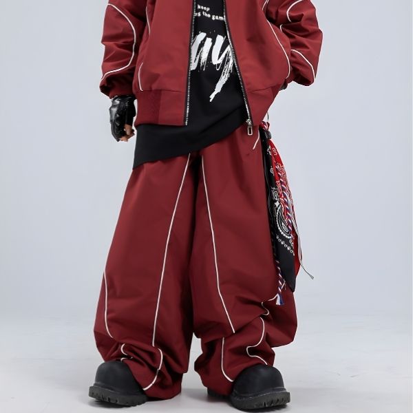 Person wearing a red tracksuit with white piping on a light gray background