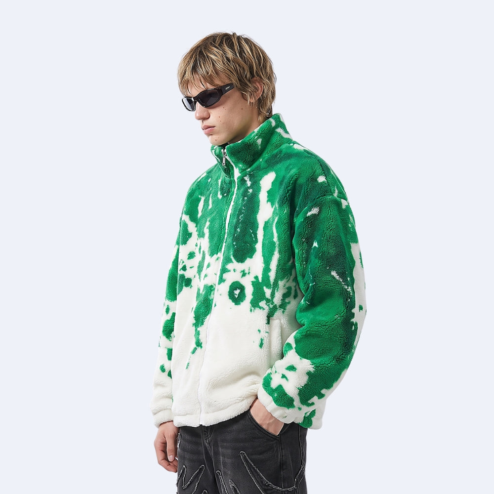 Green. A model wearing a green and white tie-dye fleece pullover jacket, styled with black sunglasses and dark jeans.