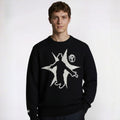 Person wearing a black sweater with a white graphic design on a white background