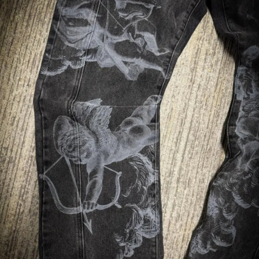 Black pants with white floral and archery design on a wooden surface