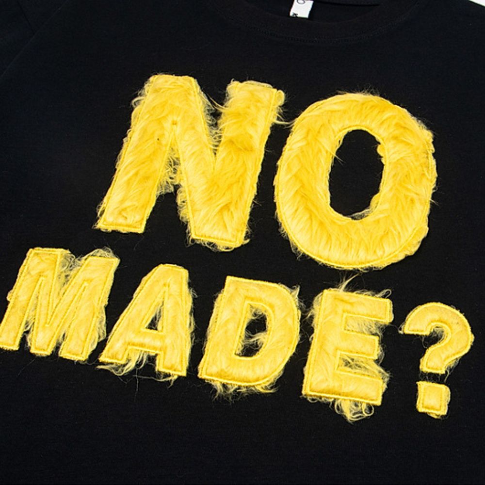 Black shirt with yellow text 'NO MADE?' on a plain background