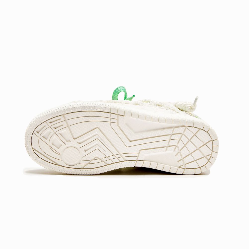 Close-up of a white sneaker sole with a green accent on a white background