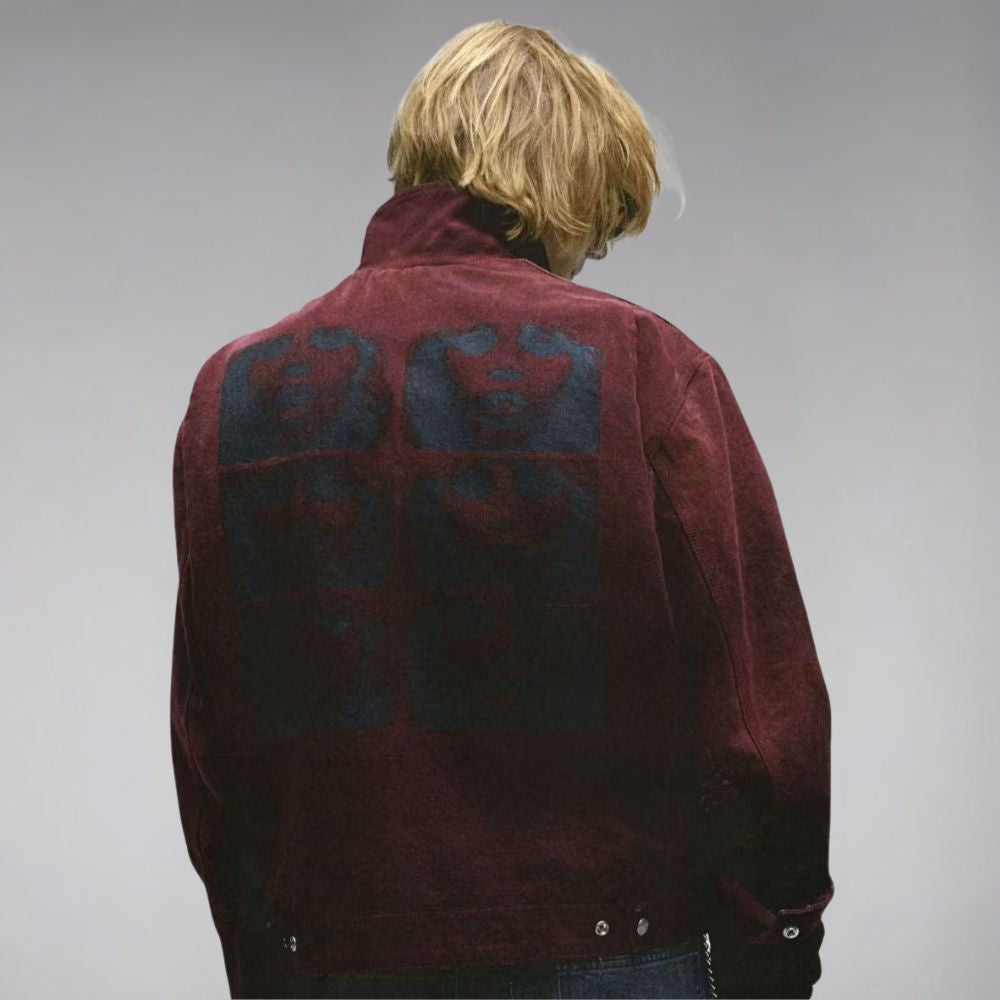 Person wearing a maroon jacket with a pattern on the back against a gray background