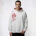 Man wearing a white hoodie with red lip print on a plain background