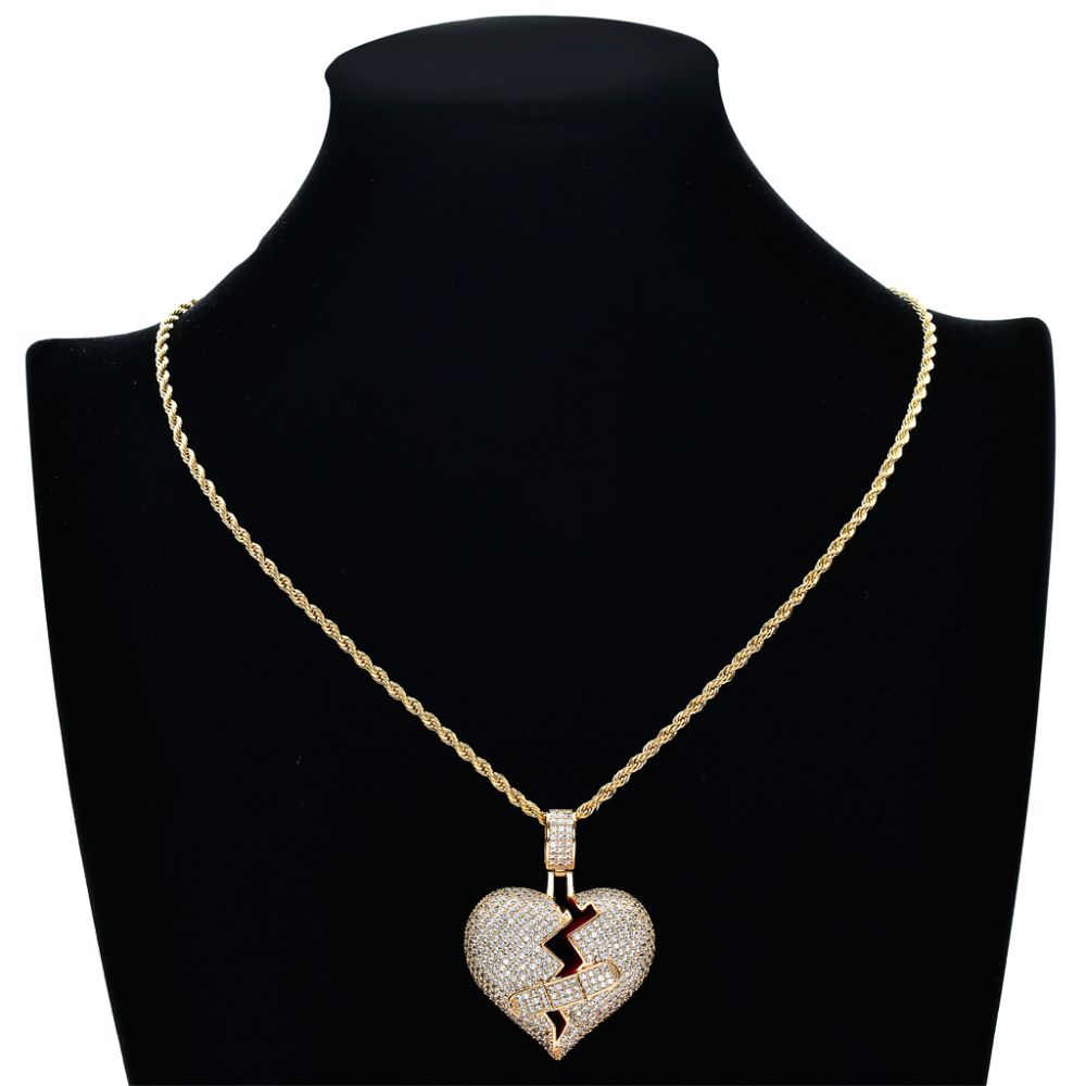 Gold necklace with a heart-shaped pendant on a black mannequin bust.