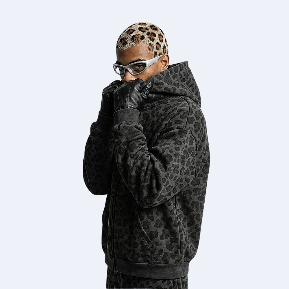 Black. KRUX Feral black leopard zip hoodie, side view on a male model with hood and ribbed cuffs