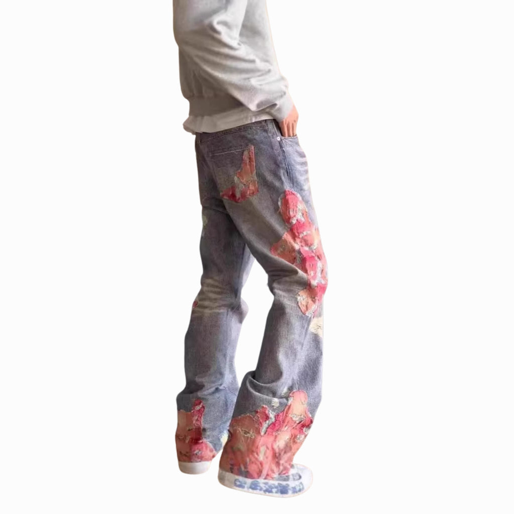 Person wearing floral-patterned jeans on a white background