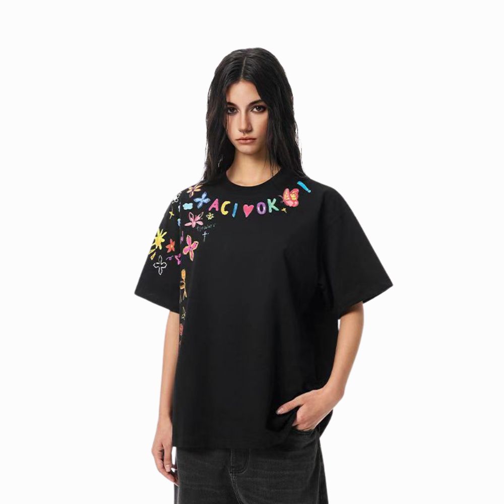 Person wearing a black t-shirt with colorful designs and text on a white background