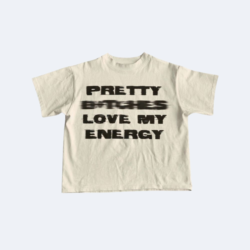 Beige. An off-white short-sleeve t-shirt with a black graphic text print, shown on a light gray background.