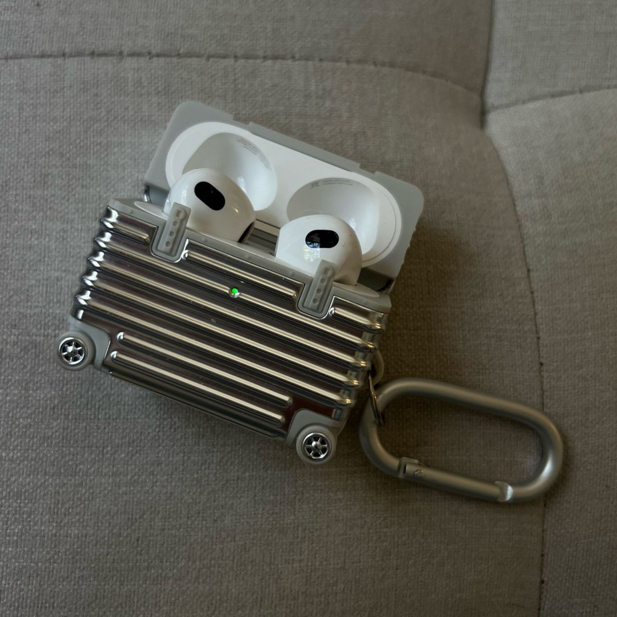 Wireless earbuds in a charging case on a textured surface