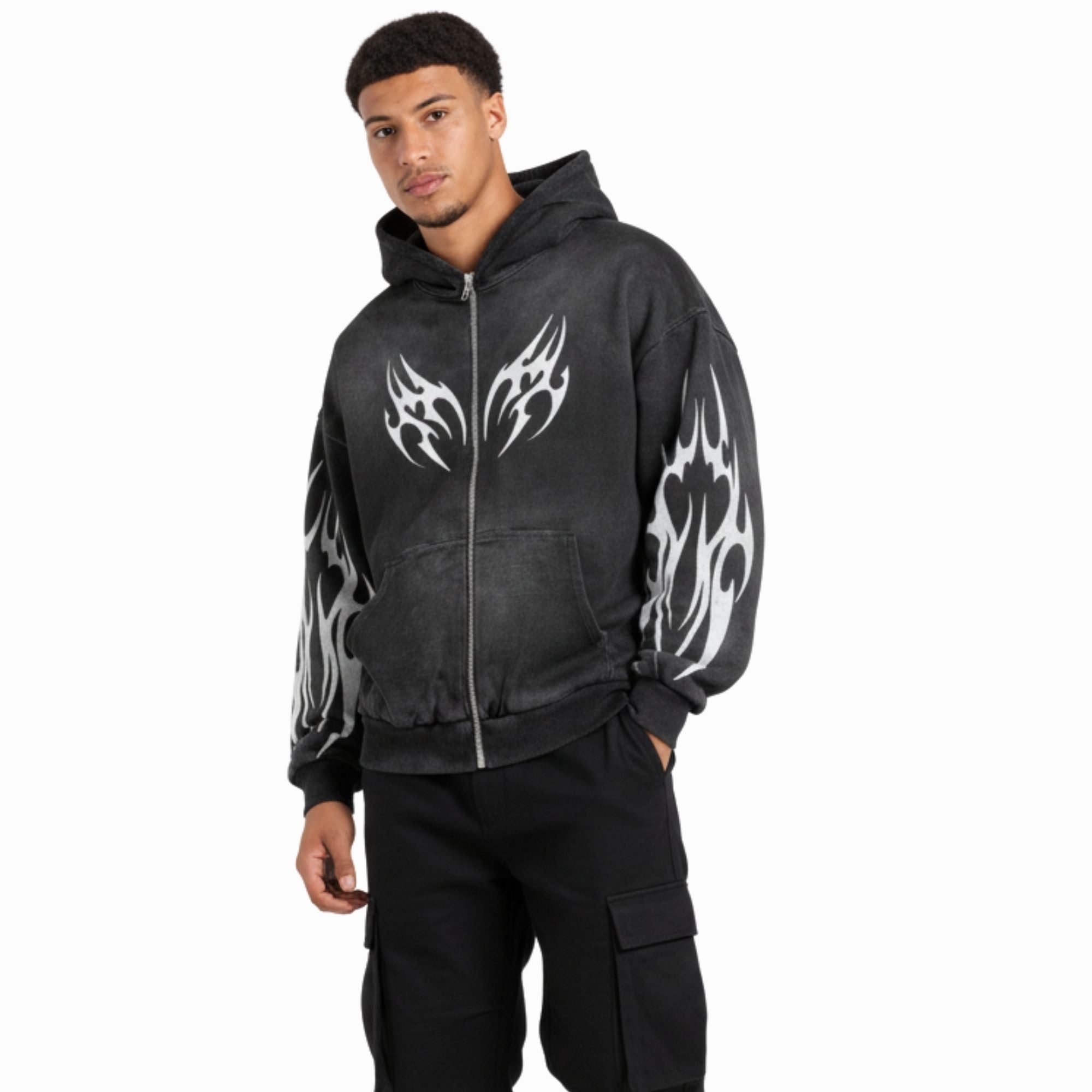 Person wearing a black hoodie with white flame designs on sleeves against a white background