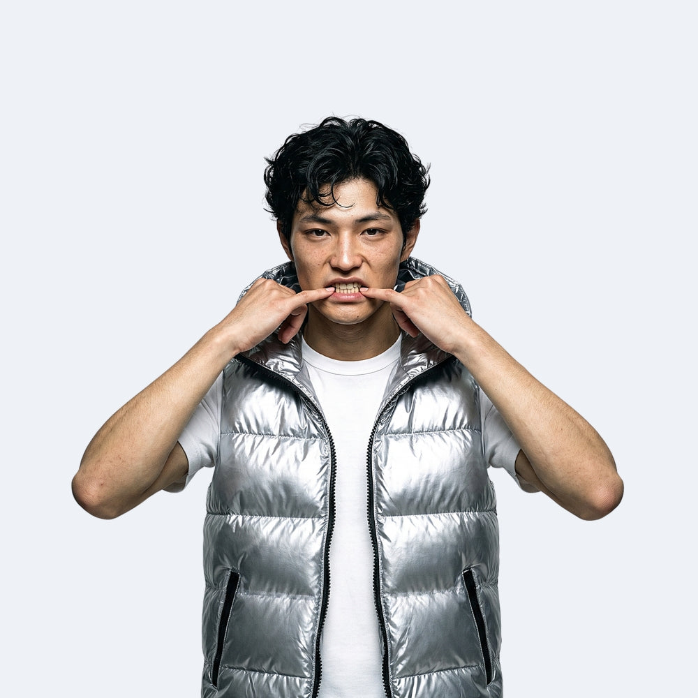 Silver. A man wearing a shiny silver puffer vest over a white t-shirt.
