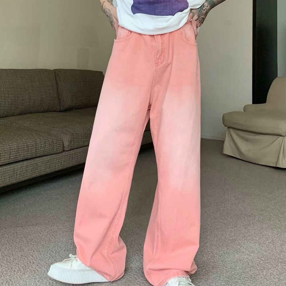 Person wearing pink pants and white shoes in a room with a brown couch.