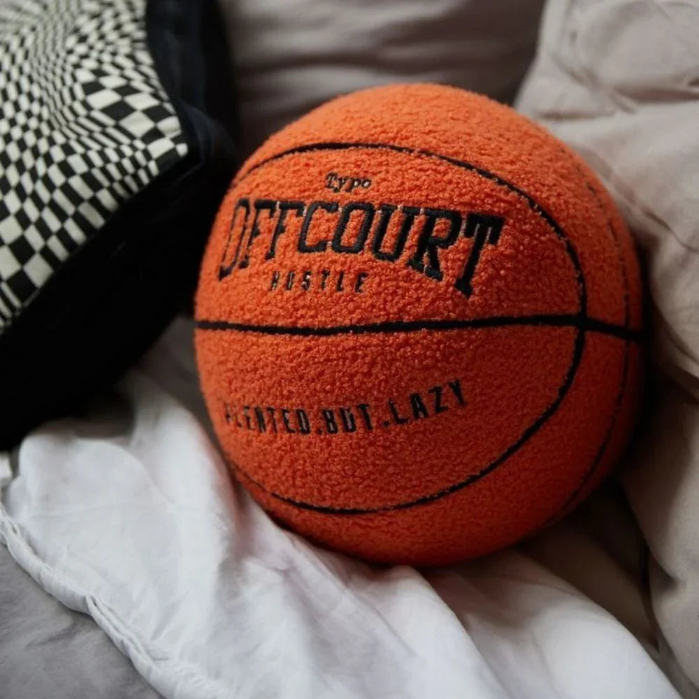 Orange pillow basketball with 'Offcourt Hustle' text on a checkered and white surface