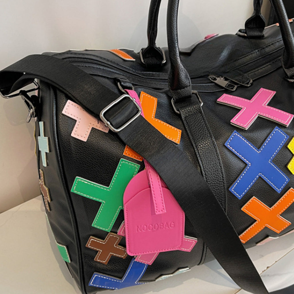 Black bag with colorful geometric patches on a light background