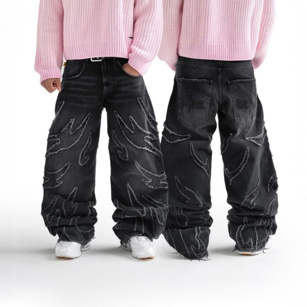 Two people wearing black jeans with white patterns on a white background