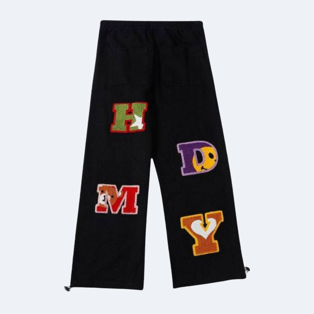 Black. Black cropped sweatpants with colorful embroidered varsity letters on the legs.