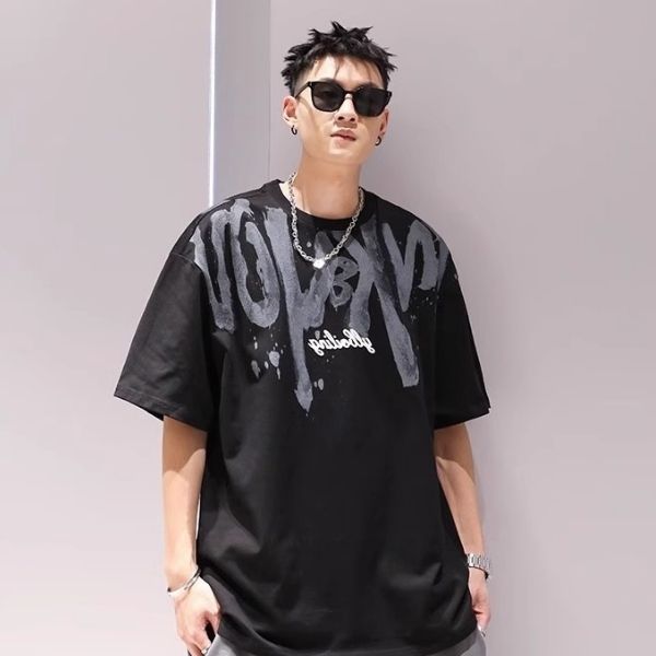 Person wearing a black t-shirt with graphic design and sunglasses against a plain background