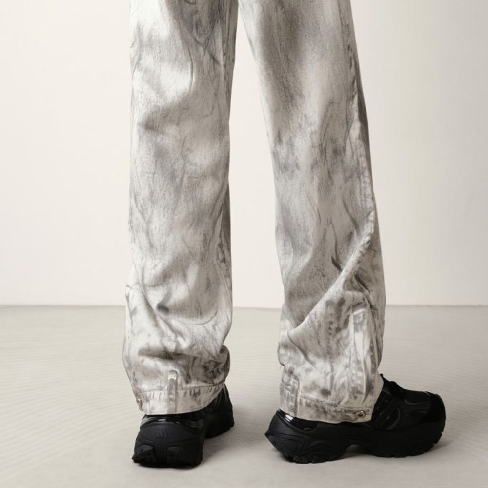 Person wearing light gray pants and black shoes on a white background