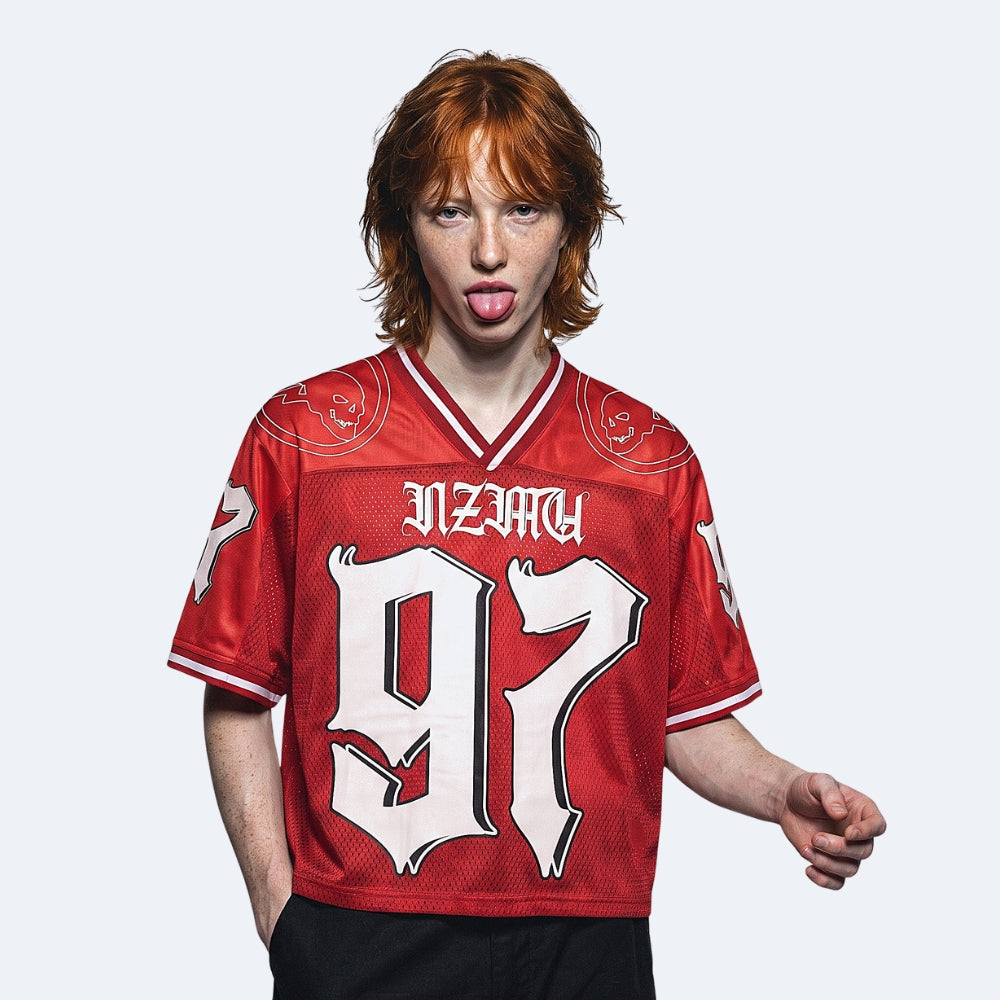 Red. A person with red hair wearing a red short-sleeve jersey with large white 97 and NZLAW lettering.