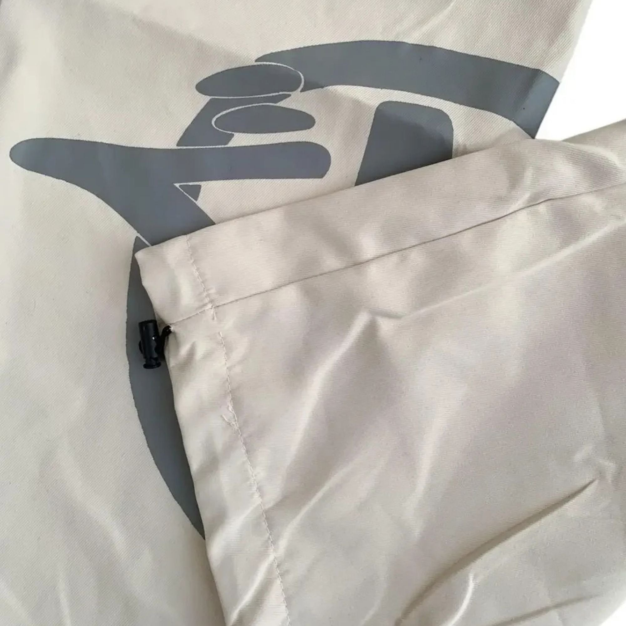 Close-up of a beige jacket with a logo on the chest