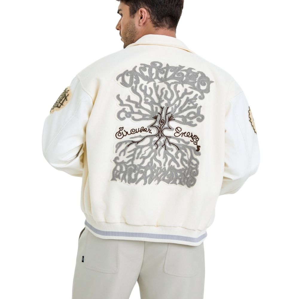 Man wearing a white jacket with intricate black designs on the back, on a white background