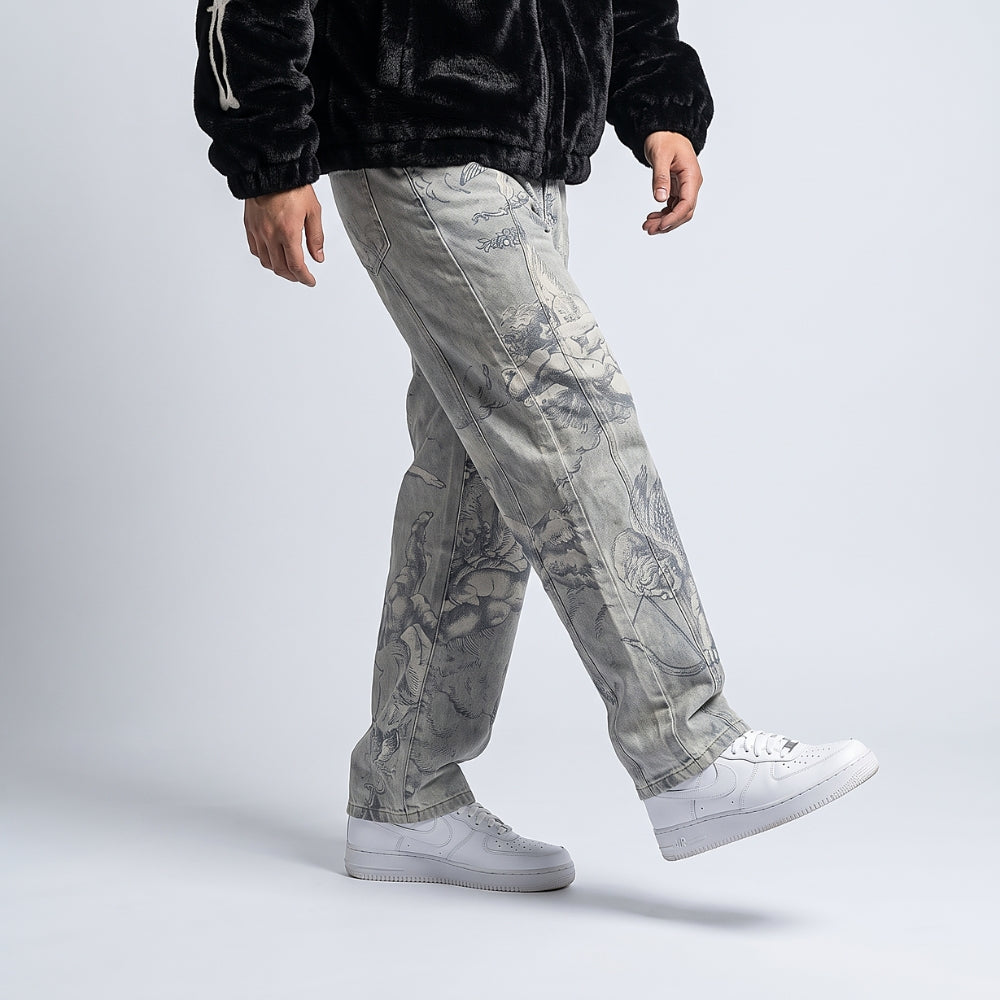 Off-White. A person wearing light gray floral print jeans, a black velour jacket, and white sneakers, shown from the chest down.