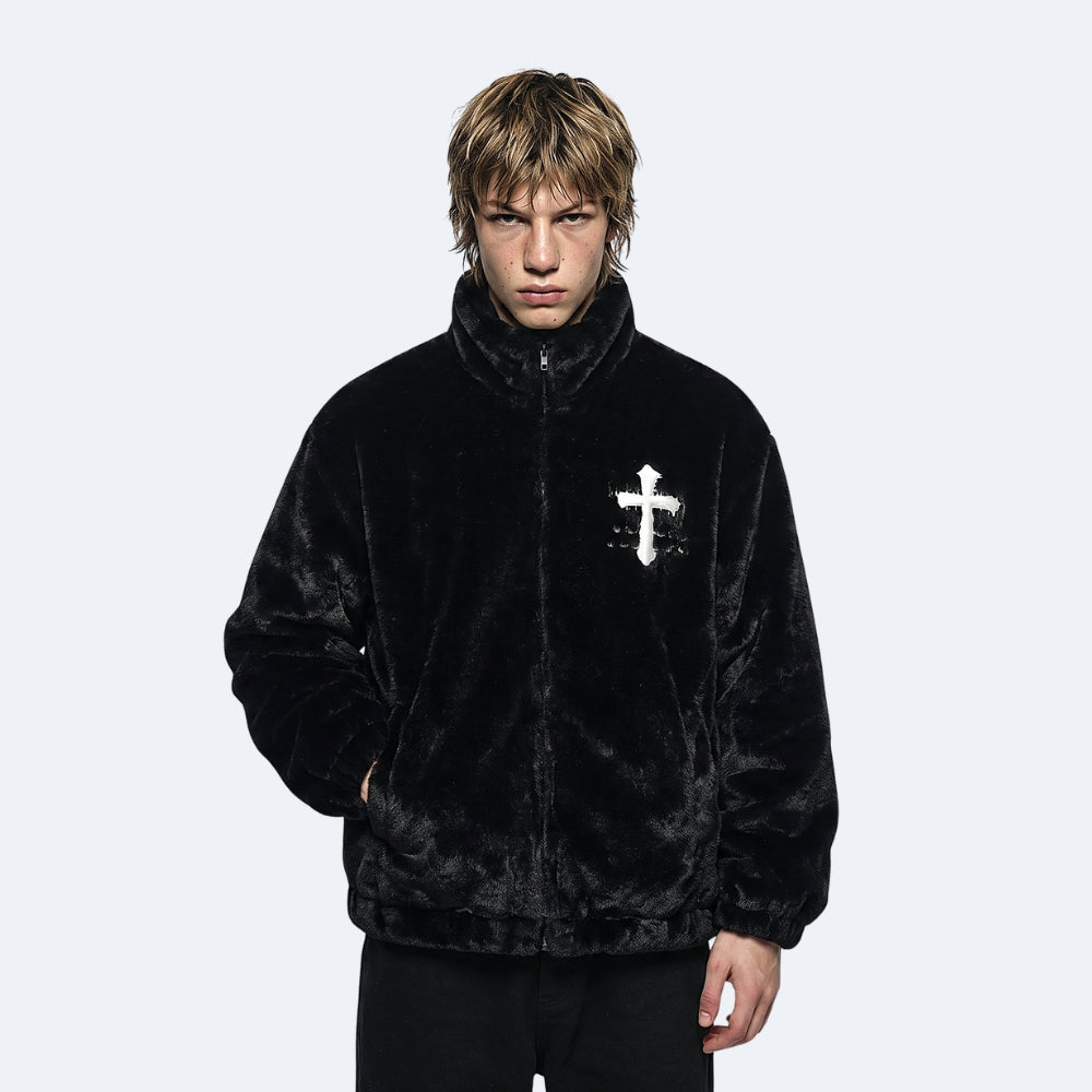 Black. A model wearing a black plush zip-up jacket with a white cross graphic on the chest.