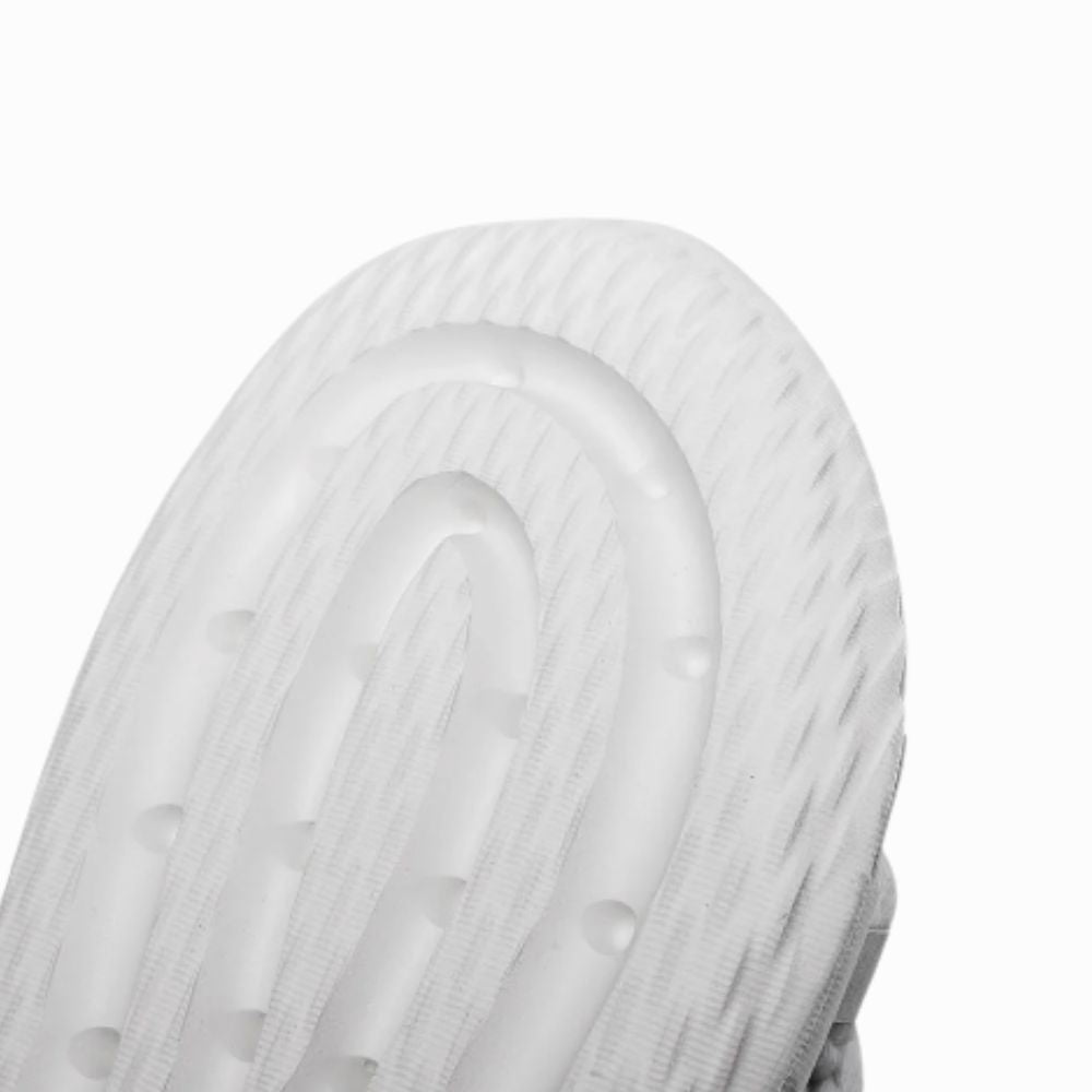 Close-up of a white sneaker with a textured sole on a white background