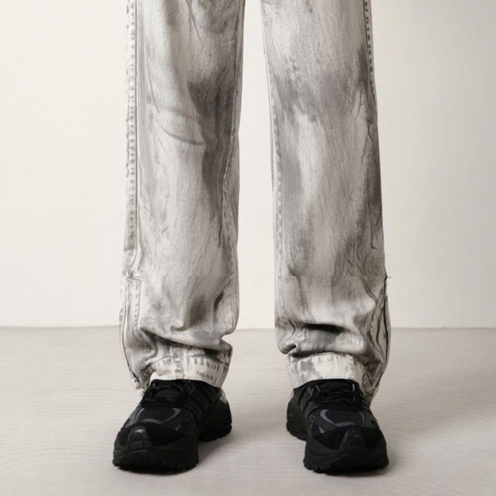 Person wearing light gray pants and black shoes on a white background