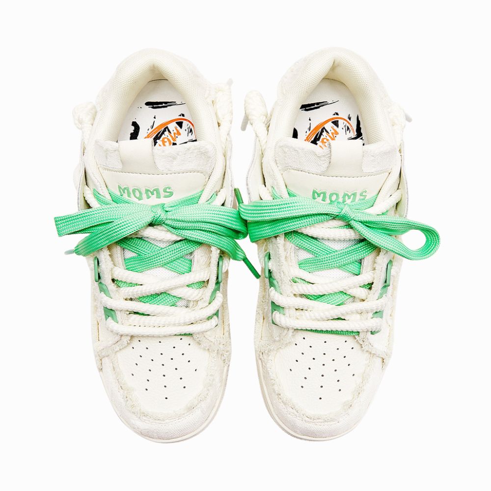 White sneakers with green laces on a white background