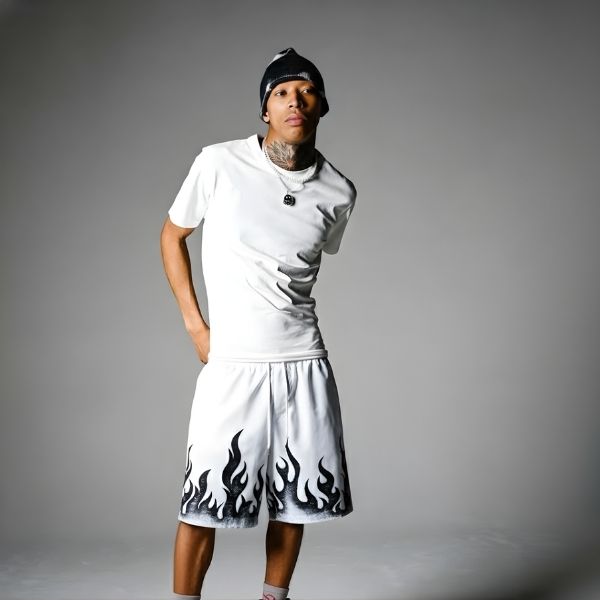 Person wearing a white outfit with flame patterns on shorts against a gray background