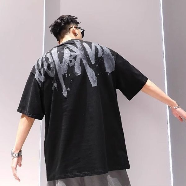 Person wearing a black t-shirt with white text design on the back against a plain background
