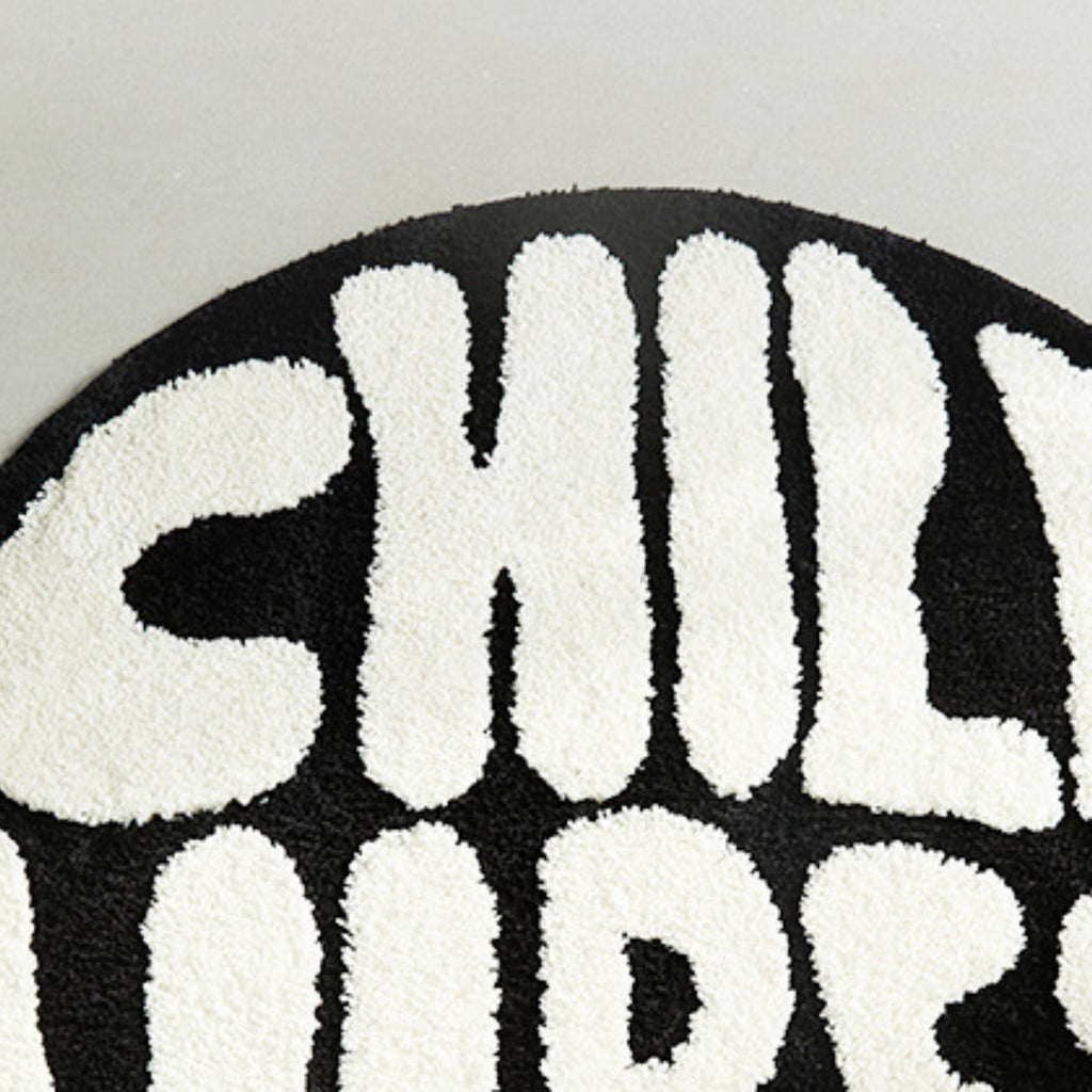 Close-up of a black and white patterned rug with text.