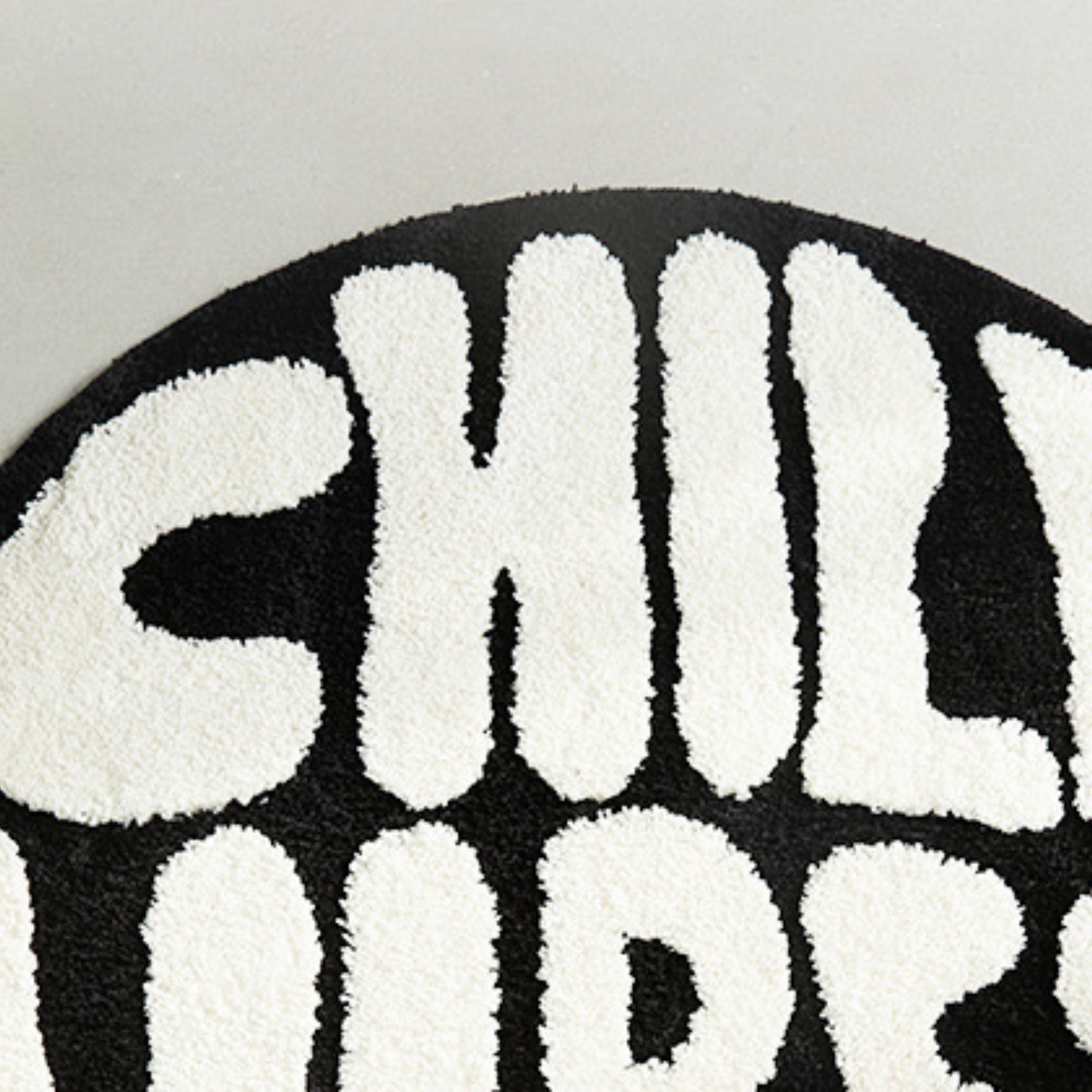Close-up of a black and white patterned rug with text.