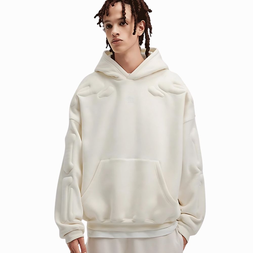 Person wearing a cream-colored hoodie on a white background