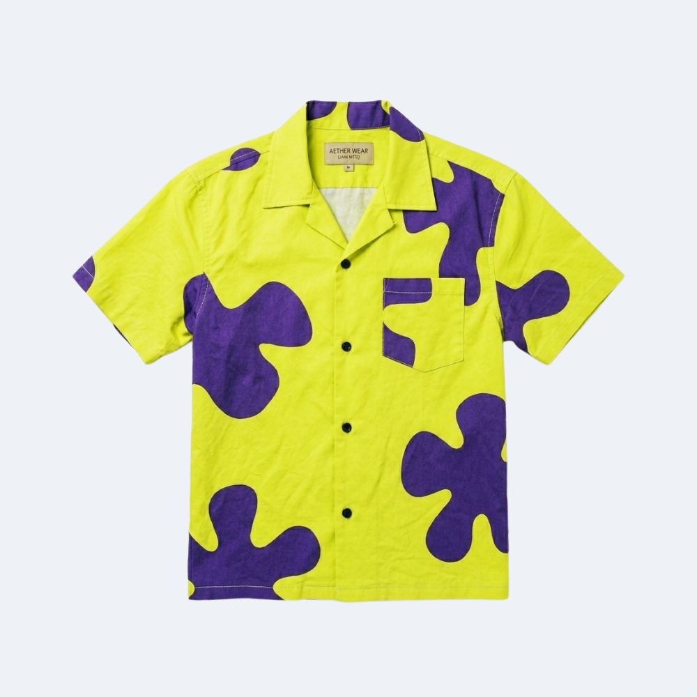 Yellow & Purple. A short-sleeve button-up camp shirt in bright yellow with large purple abstract organic shapes, displayed flat.