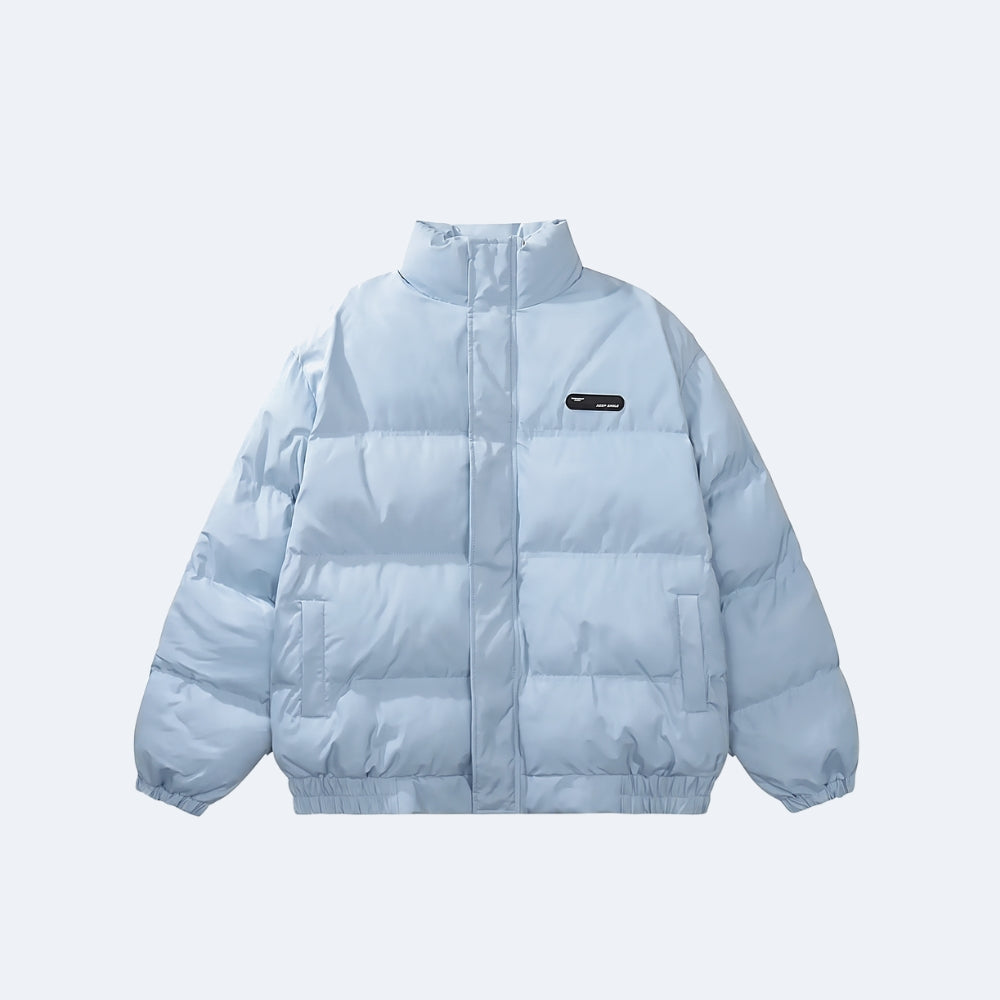 Blue. A light blue puffer jacket with horizontal quilting, a stand-up collar, and a small black rectangular logo patch on the left chest.