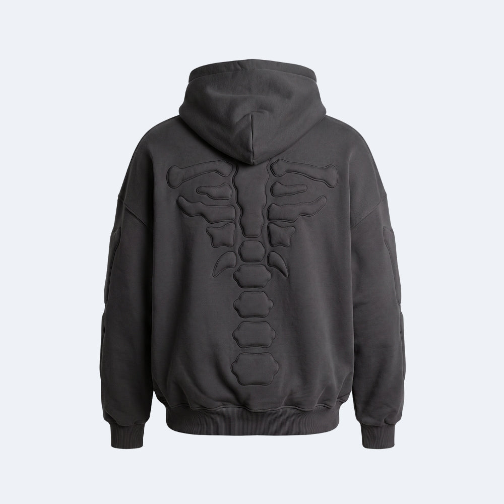 Black. A dark gray pullover hoodie shown from the back, featuring a large raised 3D rib cage design across the upper back.