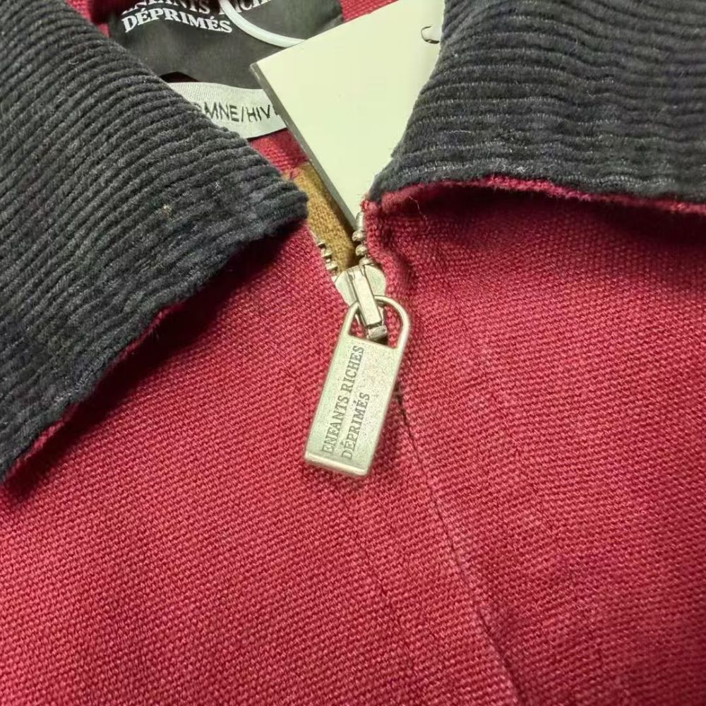 Close-up of a red jacket with a zipper and 'Dior' label.