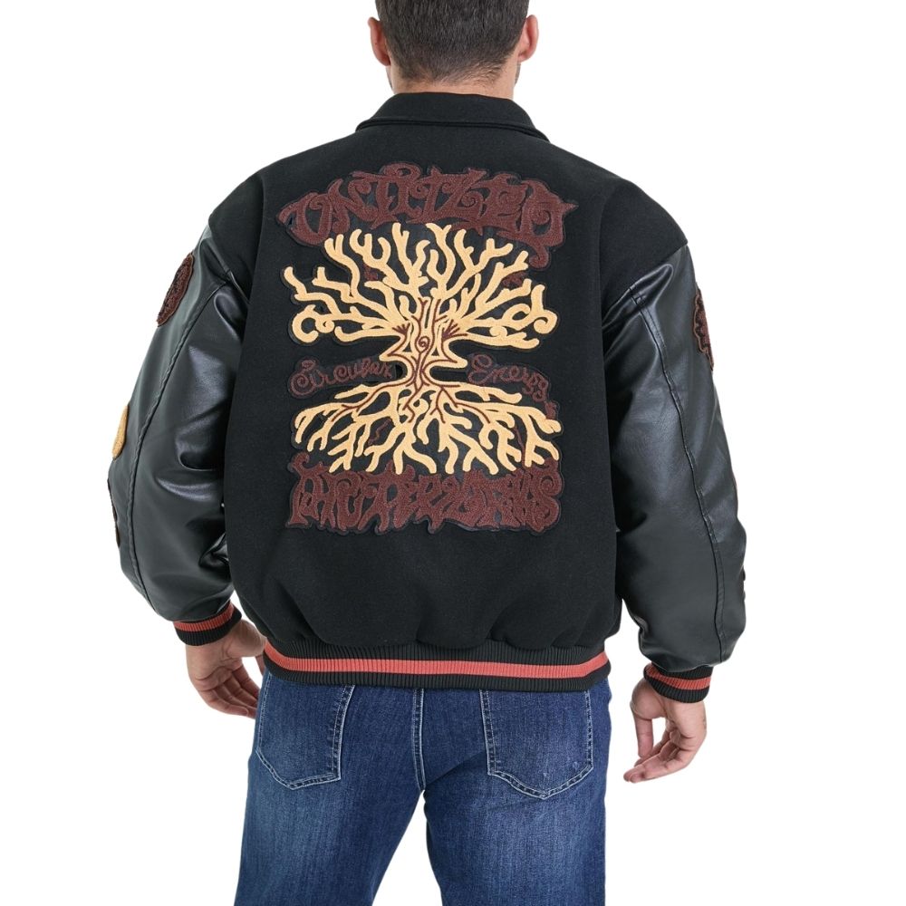 Black varsity jacket with tree design on the back, worn by a person.