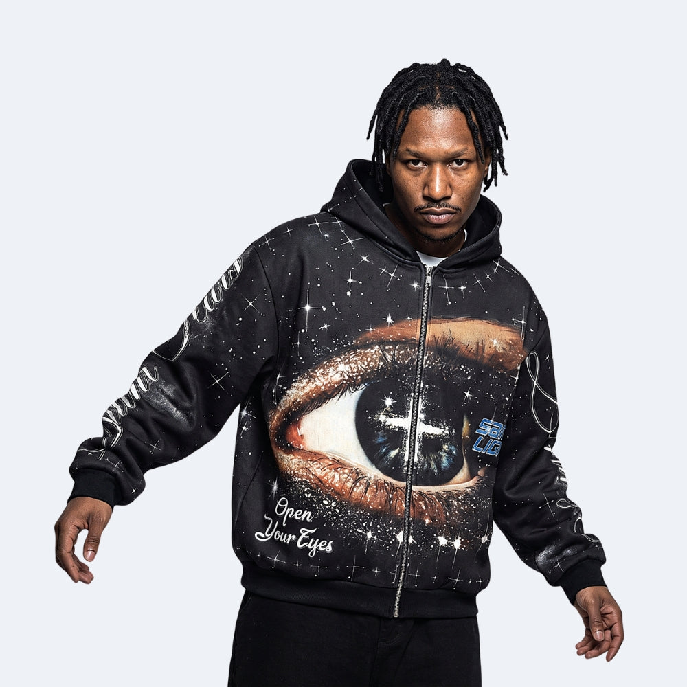 Black. A man modeling a black zip-up hoodie with a large cosmic eye graphic on the front, featuring white text reading Open Your Eyes and a small blue graphic on the chest.