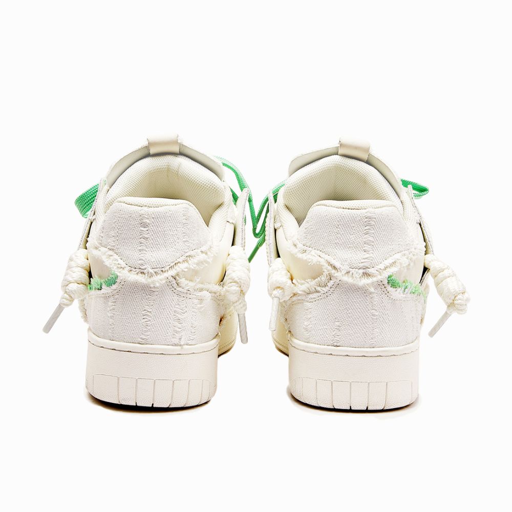 White sneakers with green accents on a white background