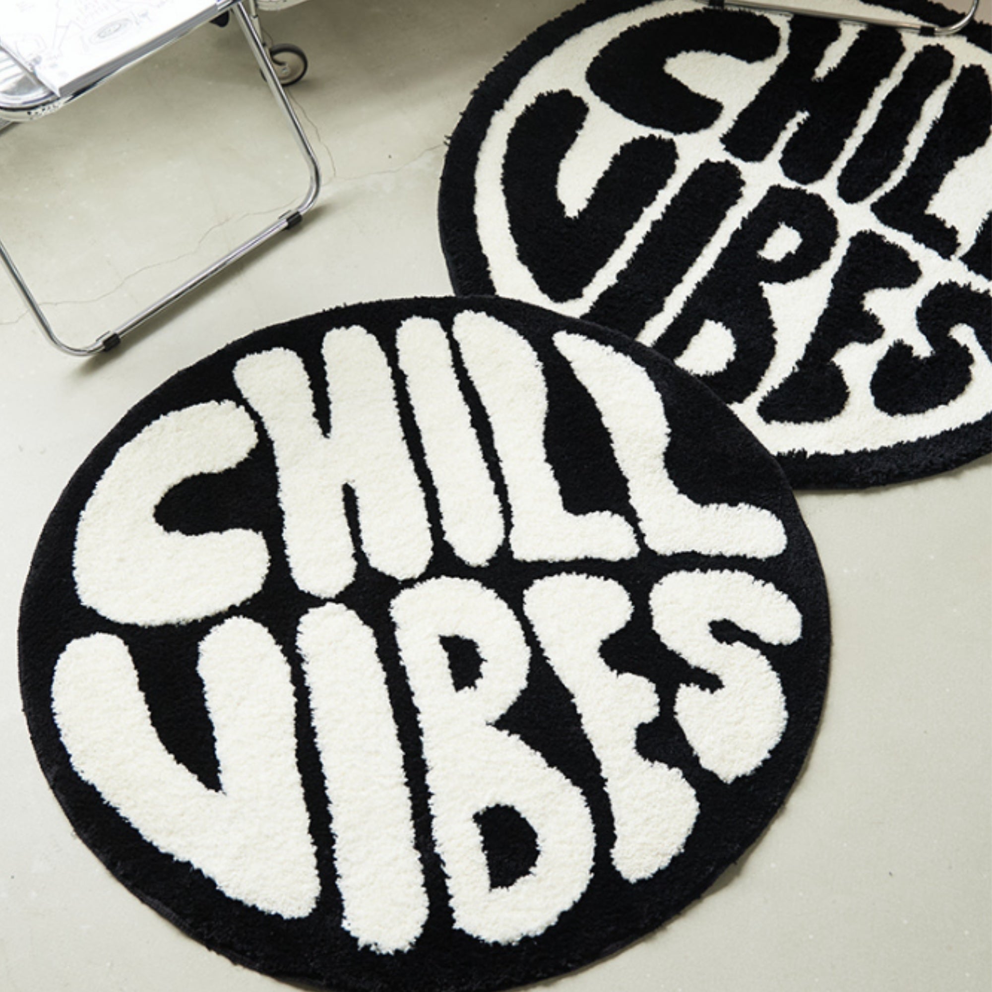 Round black and white rug with 'Chill Vibes' text on a light gray floor.