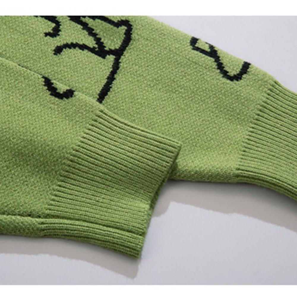 Green knitted item with black patterns on a white background