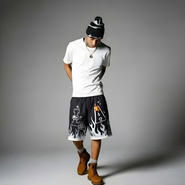 Person wearing a white t-shirt, black and white shorts, and brown boots on a gray background